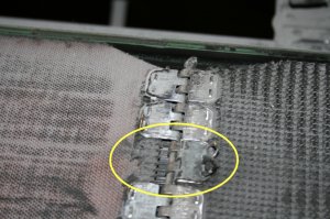 Le joint métallique de type "Alligator" de cette courroie de convoyeur se compose de plusieurs attaches. L’une d’entre elles est arrachée, ce qui induit un problème de qualité au niveau des produits qui  sont transportés par ce convoyeur. De plus, il y a augmentation des contraintes au niveau des autres attaches ce qui va inévitablement engendrer le bris de la courroie si l'on ne corrige pas la situation.